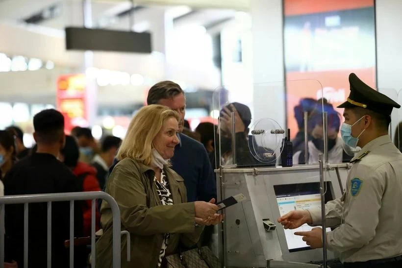 Aviation security staff verify passenger information before security screening at an airport in Vietnam.