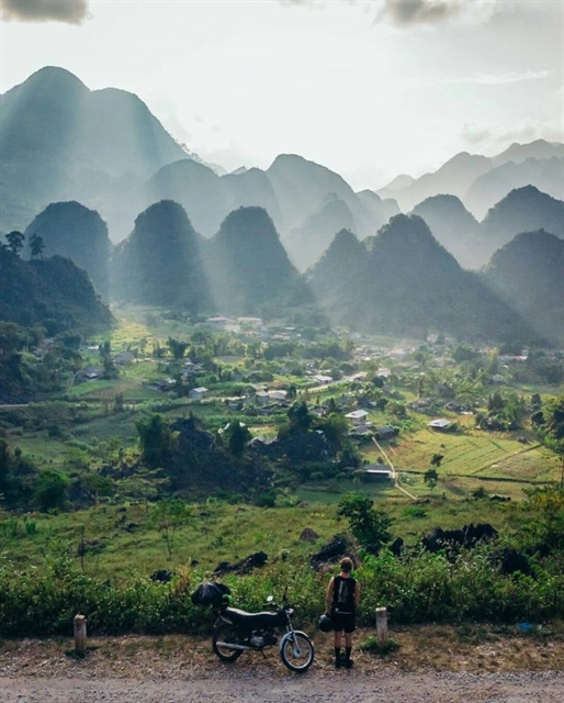 A tourist enjoys a beautiful scene in Du Già Village. — Photo farwego.vn