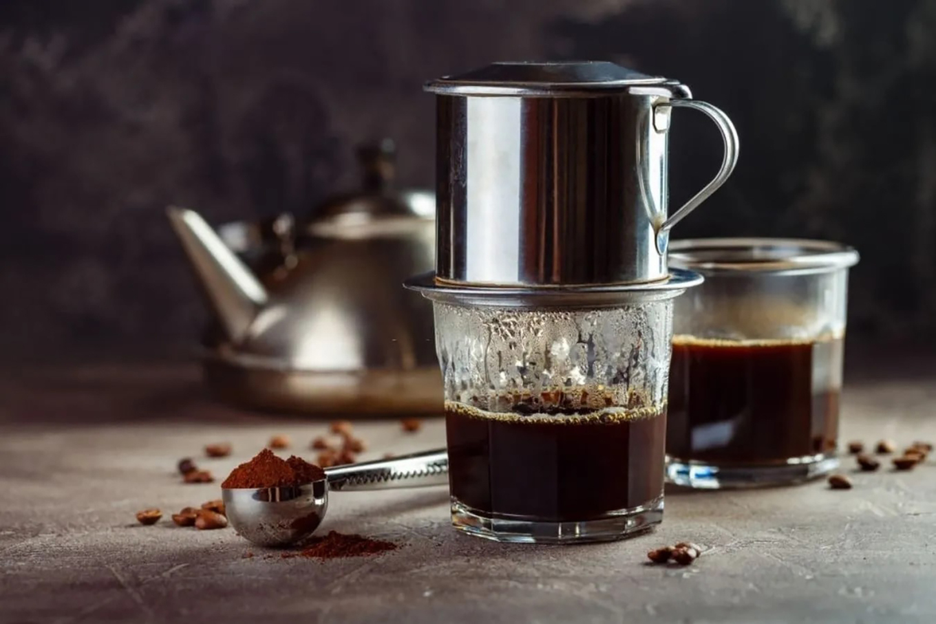 A cup of coffee slowly brews through a traditional phin filter. Photo by Mina