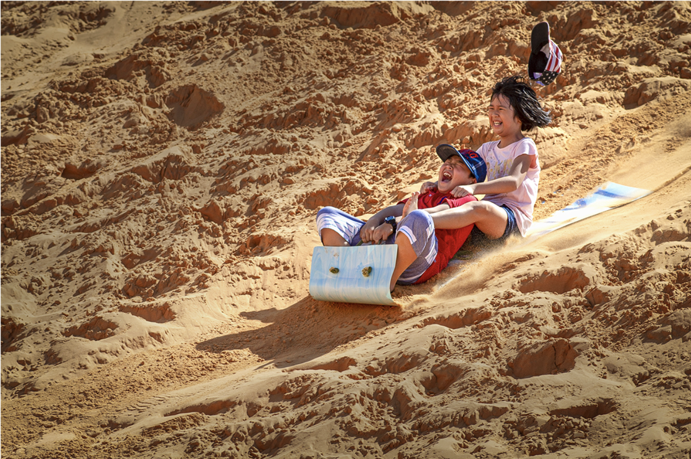 Tourists are experiencing sand sliding activities